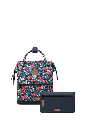 Blumenmuster-Rucksack in Grün, Rot und Weiß mit einem Handgriff oben und einer Reißverschlusstasche vorne, kombiniert mit einer navyblauen Reißverschlusstasche.