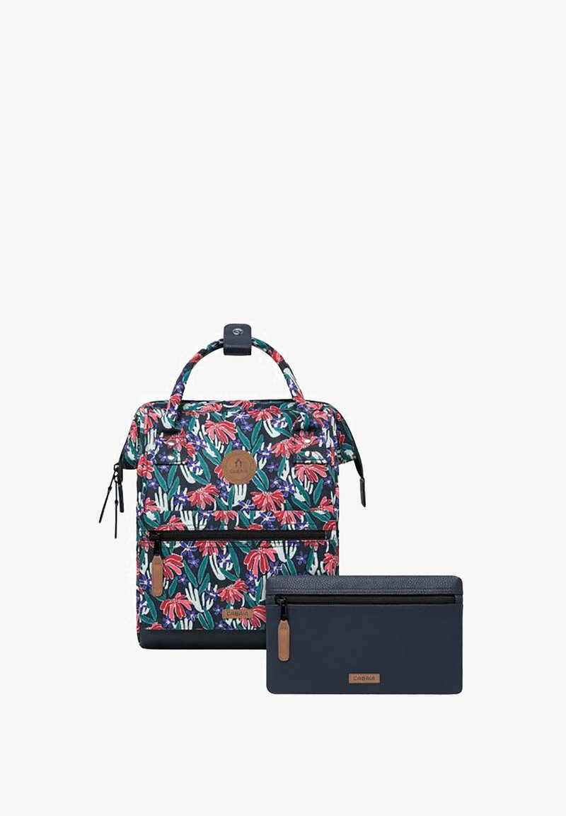 Blumenmuster-Rucksack in Grün, Rot und Weiß mit einem Handgriff oben und einer Reißverschlusstasche vorne, kombiniert mit einer navyblauen Reißverschlusstasche.