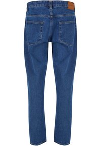 Modré džíny s rovnými nohavicemi, které mají dvě zadní kapsy, koženou nášivku na pase a minimální vyblednutí nebo opotřebení.