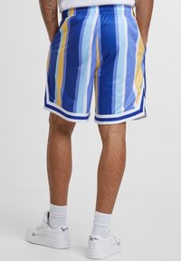 Blå og gule stripete shorts med en elastisk midje, laget av lett stoff. Har hvite detaljer og en sporty snitt.