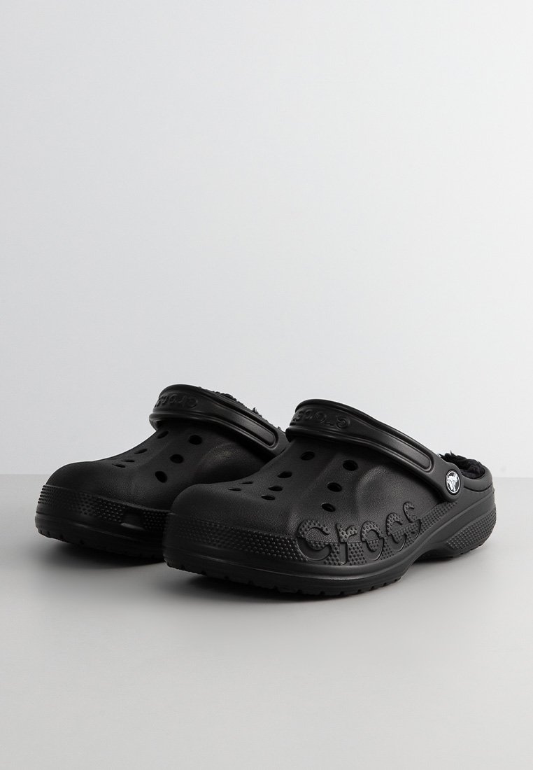 Zwarte Crocs-klompen met een getextureerd oppervlak, ronde ventilatiegaten, een achterband en een reliëfmerknaam aan de zijkant.