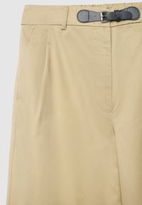 Beige maßgeschneiderte Hose mit glatter Textur, seitlichen Taschen und einem kontrastierenden schwarzen Gürtel mit silberner Schnalle.