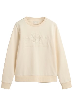 Kremkrāsas sporta krekls ar ribinātu apļa izgriezumu, mīksts kokvilnas materiāls, izspiestais GANT logotips un brīva piegriezuma siluets.