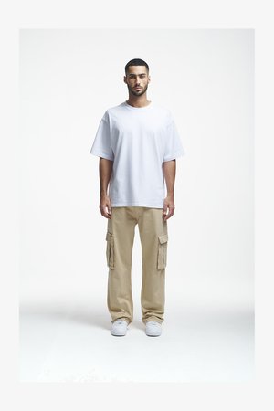 Valge puuvillane t-särk, millel on mugav lõige, koos beežide cargo-pükstega, millel on küljetaskud, ja valged tossud. Lihtne ja praktiline disain.