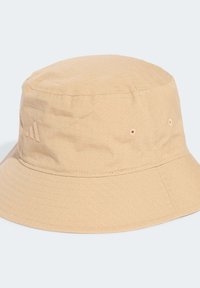 Beige bucket hat made of textured fabric, featuring a grid pattern, stitched seams, and small ventilation holes. Brand logo on the side.