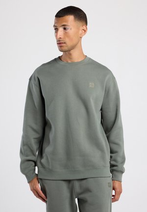 Lichtgroene fleece sweatshirt met een ronde hals, ribbelmanchetten en tailleband. Heeft een klein, getextureerd logo op de borst. Zachte textuur.