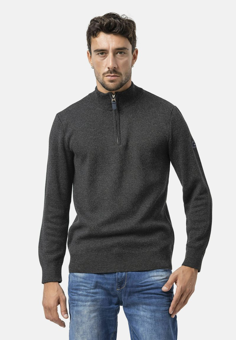 Donkergrijze zip-neksweater in een gestructureerde brei, met een geribde kraag, manchetten en zoom, gecombineerd met blauwe jeans.