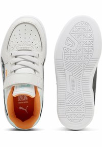 Baskets de sport blanches avec un côté noir, dotées d'une languette rembourrée, d'un bout perforé, d'un intérieur orange et de semelles en caoutchouc non marquantes.