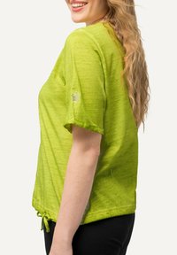 Zelený krátký rukáv top s texturovaným vzhledem, který má detail hvězdy na rukávu a nastavitelné zavázání na spodním lemu.