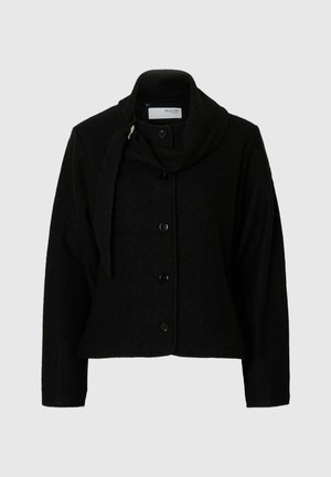 Veste noire pour femmes avec boutons, manches longues et col drapé, présentant un détail de foulard attaché sur un fond uni.