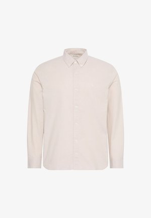 Langærmet beige skjorte med knapper, spidst krave og lille broderet logo på venstre bryst, vist på hvid baggrund.