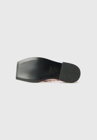 Black heeled shoe with a smooth, glossy finish, featuring a slight curve at the toe and metallic accents along the side.