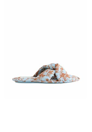 Light blue flat slide sandal with brown floral print and wide twisted fabric strap across the top.