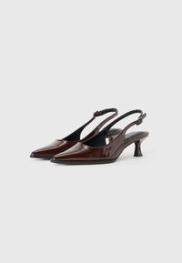 Tacchi slingback in pelle lucida marrone con punta affilata, cinturino alla caviglia regolabile e tacco a blocco basso. Texture liscia con finitura brillante.