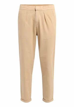 Pantalons décontractés beiges avec plis, taille élastique, jambe fuselée et ourlets roulés ; fabriqués en tissu léger et doux.
