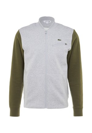 Grijze en olijfgroene zip-up jack met een staande kraag, twee vo zakken, een geaccentueerde borstzak met ritssluiting en een klein logo op de borst.