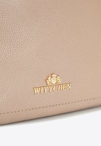 Beige kožená kabelka s texturovaným povrchem, šitými detaily a zlatým embosovaným logem "WITTCHEN" s designem erbu.