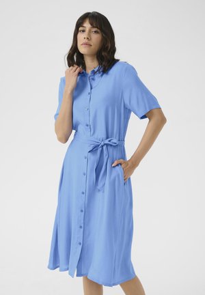 Rochie cămașă de culoare bleu deschis, fabricată dintr-un material moale. Prezintă nasturi pe toată fața, mâneci scurte, un brâu din același material și buzunare laterale.