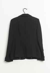 Blazer noir avec un design structuré, un col cranté, des manches longues et un ourlet arrondi. Tissu texturé avec des accents de boutons sur les manches.