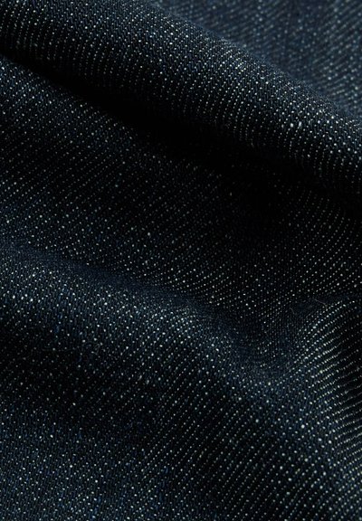 Ci ciemnoniebieski dżins ma miękką teksturę, z delikatnym połyskiem i widocznym wzorem splotu. Nici wydają się ciasno tkane z subtelnymi refleksami.
