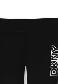 Czarne legginsy wykonane z elastycznego materiału, z białym logo "DKNY" po lewej stronie. Gładka tekstura i dopasowany krój.