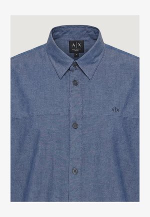 Męska koszula w średnim odcieniu niebieskiego z kołnierzykiem, czterema widocznymi guzikami oraz logo "A|X" na piersi i metką wewnątrz kołnierza.