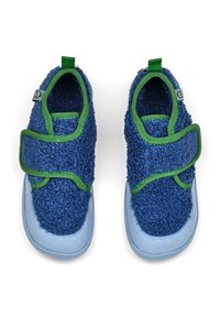 Ein Paar blaue Kinderschuhe mit grünem Rand und Klettverschluss, aus einem strukturierten, flauschigen Material und mit hellblauen Sohlen.