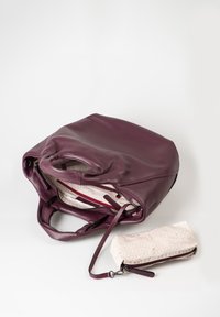 Borsa a tracolla in pelle marrone bordeaux con finitura texturizzata, dotata di un interno chiaro e una piccola pochette coordinata con un motivo geometrico.