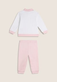 Top blanco de manga larga con detalles en rosa y pantalones deportivos elásticos rosa. Tejido suave y elástico; diseño sencillo adecuado para uso casual.