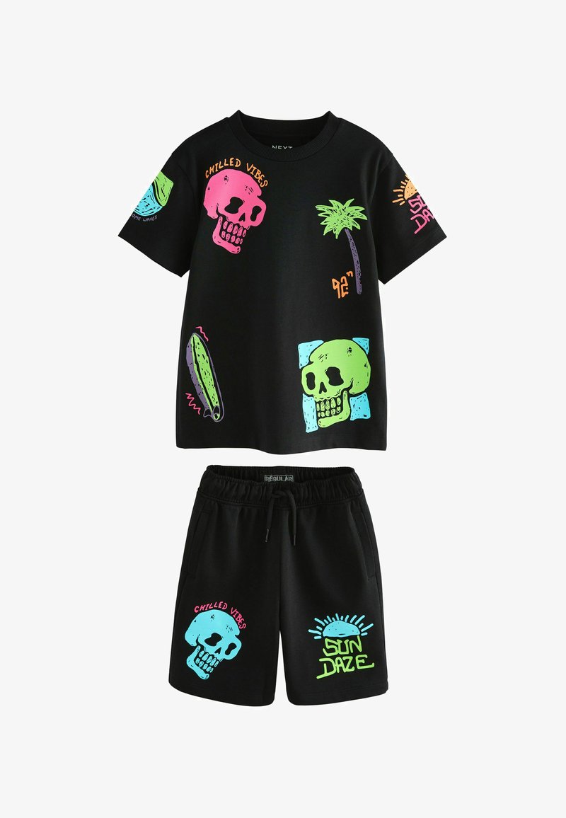 Completo con maglietta a maniche corte nera e pantaloncini con teschi al neon, una palma, una tavola da surf e testo che dice "Chilled Vibes" e "Sun Daze."