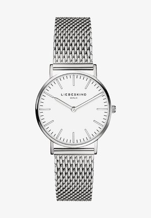 Rund sølvur med en hvid urskive, minimalistiske sorte timemarkører og et netværk af rustfrit stål. Har en simpel krone til justeringer.