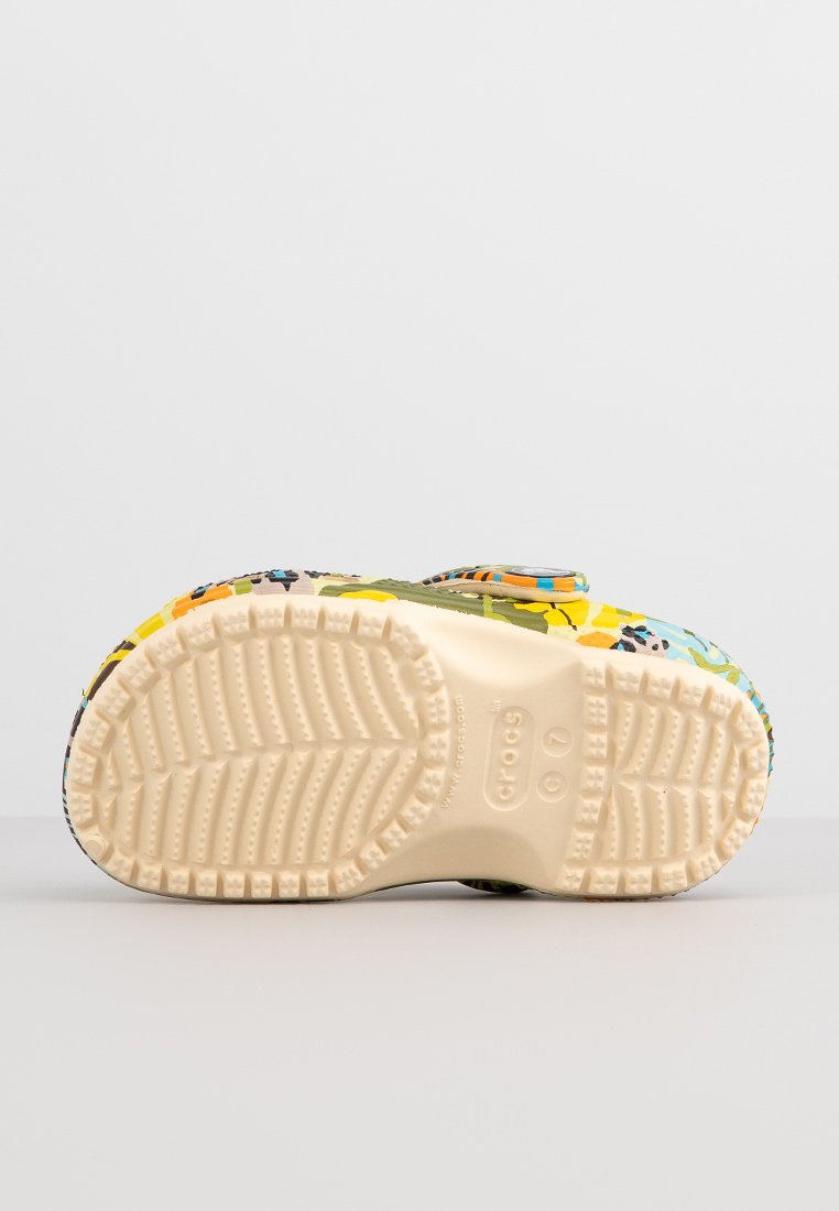 Zuecos coloridos con un patrón floral y suela blanca texturizada. Presentan una cinta ancha y un acabado suave. Están hechos de material ligero.