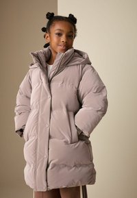 Fényes felületű, világos taupe színű pehelydzseki, nagy kapucnival, elülső zsebekkel és patentgombokkal. Bélelt, steppelt mintával a jó szigetelésért.