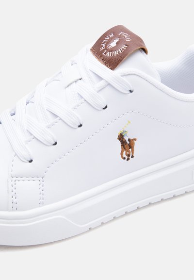 Biały tenisówka z białymi sznurowadłami, brązową skórzaną metką z wytłoczonym napisem "Polo Ralph Lauren" oraz haftowanym logo gracza polo po boku.