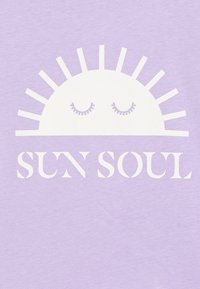 Camiseta de color púrpura claro con un gráfico de sol blanco que tiene los ojos cerrados y rayos, junto con el texto "ALMA SOL" en una fuente blanca en negrita.