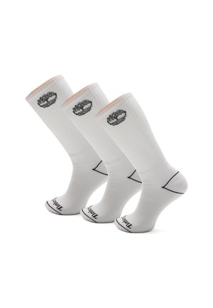 Hvide træningsstrømper i et sæt af tre, med ribbet tekstur, kontrasterende sort logo og farveaccentuationer på manchetterne.