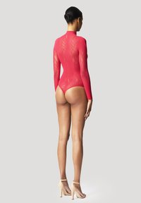 Body rosso a maniche lunghe con un motivo trasparente e texturizzato, colletto alto e vestibilità aderente. Abbinate a sandali con tacco nudo.