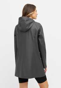 Grijze waterdichte regenjack met capuchon, gladde textuur, lange mouwen en een middellange snit, ontworpen voor functionaliteit en bedekking.