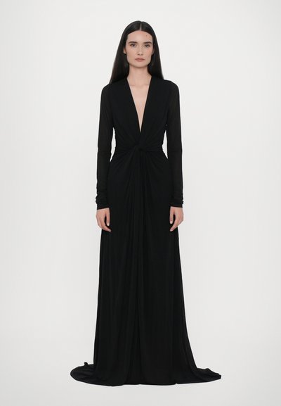 Vestido negro hasta el suelo con escote en V profundo y mangas largas. Presenta un detalle central fruncido y una tela fluida con una textura suave.