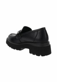 Zapato de cuero negro con suela gruesa, diseño curvado y una correa decorativa en la parte superior. Suela de goma texturizada con profundos surcos.