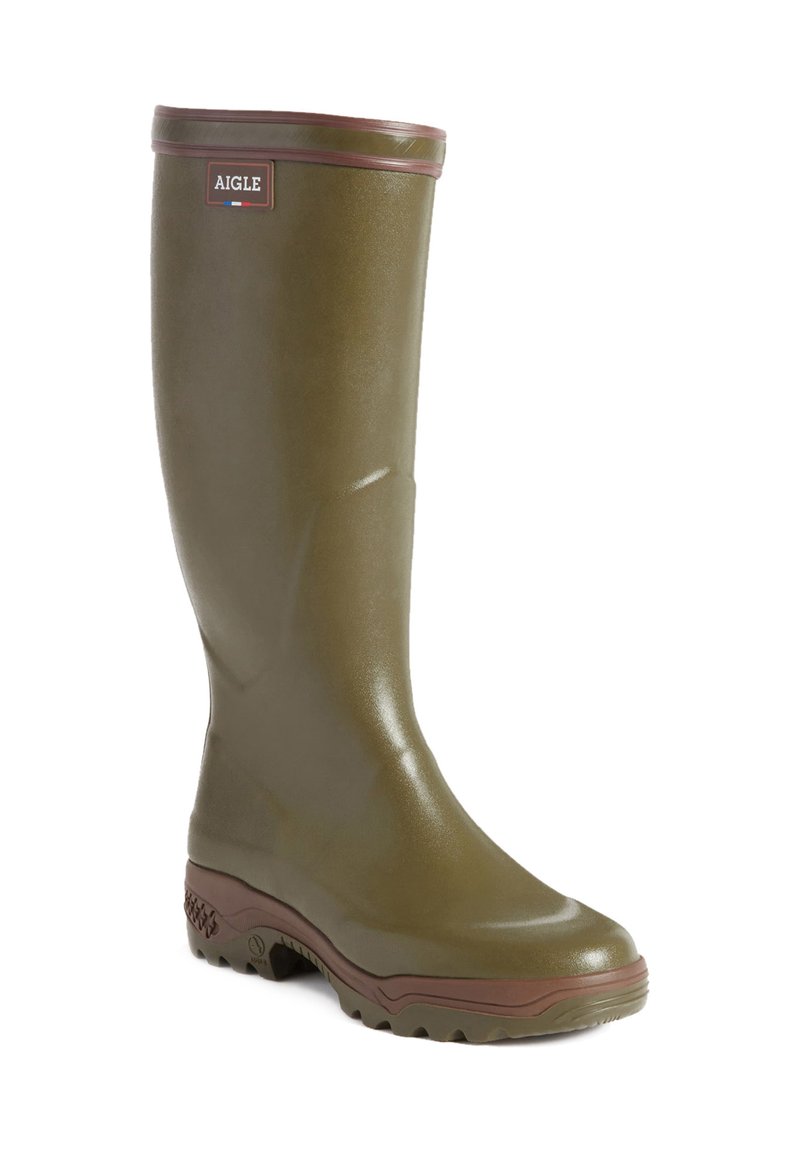 Green rubber knee-high boot with brown accents, textured finish, and a chunky sole. Features a logo badge near the top. Round toe design.