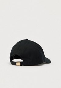 Casquette de baseball noire à visière courbée, en tissu avec une surface texturée, dotée d'une sangle ajustable avec un détail en métal à l'arrière.