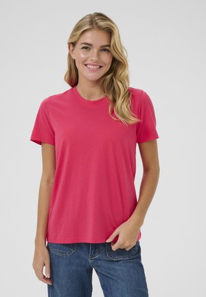 Short-sleeve, crew-neck T-shirt in bright pink cotton, featuring a relaxed fit and smooth texture. Worn with blue denim jeans.