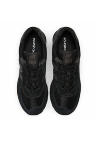 Black New Balance 574 sneakers featuring mesh and suede materials, a round toe shape, lace-up design, and prominent branding on the tongue.