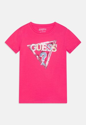 Rosa Baumwoll-T-Shirt mit einem dreieckigen "GUESS"-Logo aus Pailletten und einem markanten Fragezeichen-Detail. Kurze Ärmel und Rundhalsausschnitt.