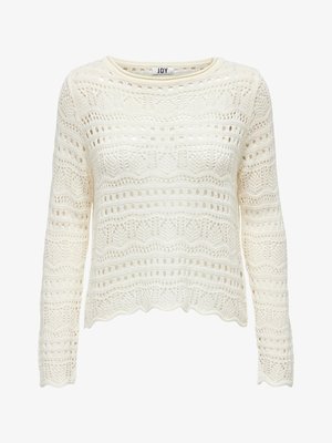 Jersey de punto de manga larga color crema con intrincados patrones de ganchillo y dobladillo con bordes ondulados, etiquetado "JDY" en el interior del cuello.