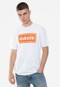 White cotton t-shirt featuring a bold orange rectangular graphic and text "oasis." Crew neck design with short sleeves. Minimalist style.