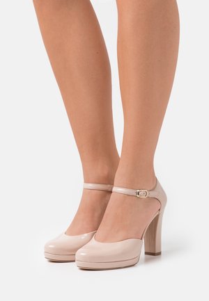 Talons en cuir verni rose avec un bout arrondi et une sangle à la cheville, présentant un talon épais et une finition lisse.