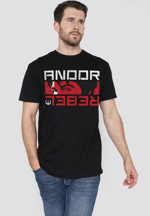 Black cotton t-shirt featuring a bold graphic print with "ANDOR" and "REBELLION" in white and red, depicting a face detail. Casual fit.