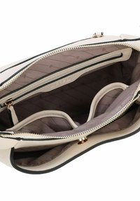 Bolso de crema con detalles en negro, que cuenta con un bolsillo interior, compartimentos con cremallera y un forro acolchado en beige. Detalles en dorado.